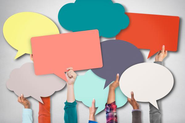 A group of hands holding up colourful speech bubbles