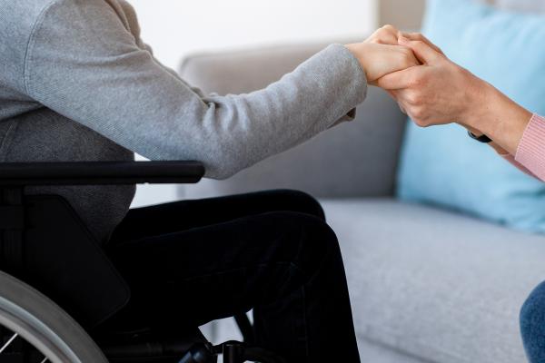 A close up of person's hand holding the hand of another person