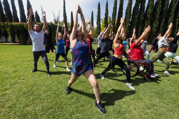 A group of adults doing yoga in the park